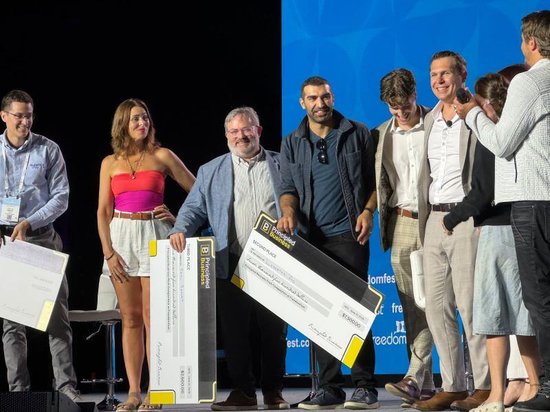 Principled Business pitch competition winners on stage with their prize checks